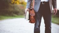 man holding book on road during daytime