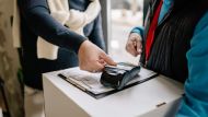 A Person in Black Long Sleeves Tapping the Credit Card on a POS Terminal